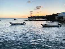 two boats in the sea with a sunset