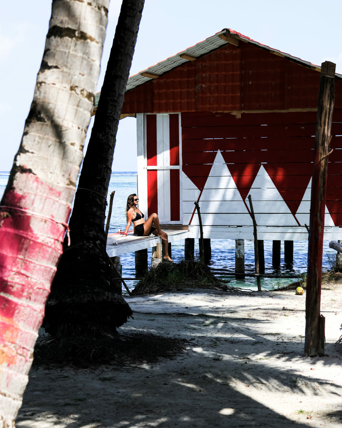 A woman sitting next to a house beach